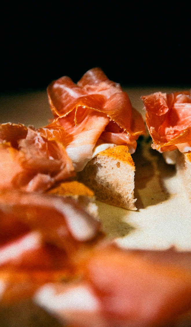 Un trozo de Pizz'otto servido con jamón serrano.