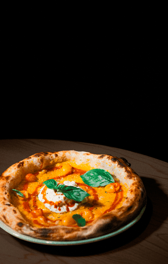 Una pizza de masa clásica con tomate, mozzarella y albahaca.